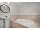This bathroom features a soaking tub, tile surround, and pedestal sink at 1210 S Clayton St, Mount Dora, FL 32757