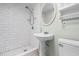 Bathroom with updated tile shower, pedestal sink and decorative mirror at 1210 S Clayton St, Mount Dora, FL 32757