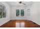 Sunny bedroom with beautiful hardwood floors, large windows, and a ceiling fan, offering a relaxing retreat at 1210 S Clayton St, Mount Dora, FL 32757