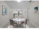 Bright dining area with a white table and four chairs next to a modern kitchen and neutral walls at 1210 S Clayton St, Mount Dora, FL 32757