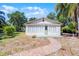 Inviting cottage-style home with a brick path, surrounded by ample greenery and a clear sky at 1210 S Clayton St, Mount Dora, FL 32757