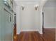 Inviting foyer featuring gleaming hardwood floors, sconce lighting, and an arched doorway leading to other living spaces at 1210 S Clayton St, Mount Dora, FL 32757