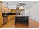 Bright kitchen showcasing wood cabinets, black countertops, an island with stools, and stainless steel appliances at 1210 S Clayton St, Mount Dora, FL 32757