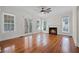 Spacious living room featuring original hardwood floors, a fireplace, and access to the outdoors through elegant french doors at 1210 S Clayton St, Mount Dora, FL 32757