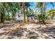 Wide shot of the property with a garage, house, and outbuilding surrounded by mature trees at 1210 S Clayton St, Mount Dora, FL 32757