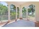 Relaxing sunroom with large arched windows providing panoramic views and a peaceful atmosphere with a neutral rug at 1210 S Clayton St, Mount Dora, FL 32757