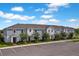 New construction townhome showcasing manicured landscaping and assigned parking at 1230 Sand Torch Cir, Davenport, FL 33837