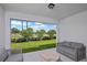 Covered outdoor lanai with gray sofa seating and views of the lush front yard and neighborhood at 1230 Sand Torch Cir, Davenport, FL 33837