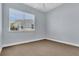 A carpeted bedroom features a large window, neutral walls, and baseboards at 1251 Arlington Pl, Winter Park, FL 32789