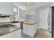 Bright kitchen with white cabinetry, granite countertops, a center island, and modern stainless steel appliances at 1251 Arlington Pl, Winter Park, FL 32789