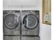 Modern laundry room equipped with front-load washer and dryer units on pedestals at 1251 Arlington Pl, Winter Park, FL 32789