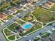 Aerial view of a community with a playground, pool, and well-maintained green spaces between modern homes at 1328 Pompay Dr, Davenport, FL 33896