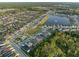 Wide aerial view of a large planned community featuring a lake, pool, and numerous single-Gathering homes at 1328 Pompay Dr, Davenport, FL 33896