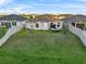 Aerial view of backyard featuring a well-manicured lawn, white fences, and an outdoor seating area at 1328 Pompay Dr, Davenport, FL 33896