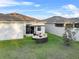 Backyard view featuring a round outdoor sofa with an umbrella and a manicured lawn at 1328 Pompay Dr, Davenport, FL 33896
