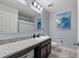 Bathroom featuring granite countertops, dark cabinets, and a large mirror with modern lighting at 1328 Pompay Dr, Davenport, FL 33896