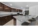 Modern kitchen with dark cabinets, granite countertops, stainless steel appliances, and breakfast bar at 1328 Pompay Dr, Davenport, FL 33896