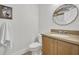 Powder room featuring wood cabinets, neutral countertops, designer mirror, toilet, painting, and white hand towel at 1342 Benevolent St, Maitland, FL 32751