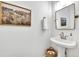 Elegant powder room featuring a pedestal sink, framed art, bronze fixtures, and a decorative mirror at 1342 Benevolent St, Maitland, FL 32751