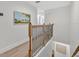 Hallway with wood floors, wooden banister, and white walls illuminated with natural light at 1342 Benevolent St, Maitland, FL 32751