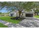 Charming single-story home featuring a well-manicured lawn, beautiful tree and paved driveway leading to the garage at 1365 Lake Dr, Casselberry, FL 32707