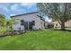 Landscaped front yard showcasing the modern exterior, green lawn and mature tree at 1365 Lake Dr, Casselberry, FL 32707