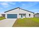 Beautiful single-Gathering home with modern architecture, a well-manicured lawn, and blue garage door at 14953 Sw 38Th Cir, Ocala, FL 34473