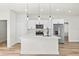 Modern kitchen with white cabinets, stainless steel appliances, an island with a quartz countertop, and wood flooring at 14953 Sw 38Th Cir, Ocala, FL 34473