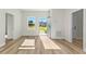 Bright living room featuring an open doorway, light wood flooring, and a view of the front yard at 14953 Sw 38Th Cir, Ocala, FL 34473