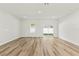 Spacious room with light wood flooring, neutral walls, and sliding glass doors to backyard at 14953 Sw 38Th Cir, Ocala, FL 34473