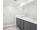 Contemporary bathroom featuring a glass-enclosed shower and double vanity with grey cabinets at 15489 Hamlin Park Drive, Winter Garden, FL 34787