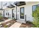 Home entrances featuring dark doors, modern address plaques, and paved sidewalks at 15489 Hamlin Park Drive, Winter Garden, FL 34787
