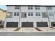 Townhome exteriors feature dark garage doors, brick-paved driveways, and small balconies at 15489 Hamlin Park Drive, Winter Garden, FL 34787