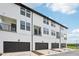 Three-story townhomes featuring private garages, balconies, and white siding at 15489 Hamlin Park Drive, Winter Garden, FL 34787