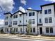 Modern townhome exterior featuring clean white facade with black trim and contemporary design elements at 15489 Hamlin Park Drive, Winter Garden, FL 34787