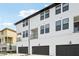 Modern townhome exterior with a balcony, dark trim windows, and attached garage in a residential neighborhood at 15489 Hamlin Park Drive, Winter Garden, FL 34787