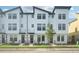 Modern townhome exterior featuring white siding, black trim, and well-maintained landscaping at 15489 Hamlin Park Drive, Winter Garden, FL 34787