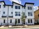 Contemporary townhome with striking white exterior, bold black window frames, and modern architectural details at 15489 Hamlin Park Drive, Winter Garden, FL 34787