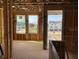 New interior under construction showing exposed framing, rough window placements and views of the surrounding neighborhood at 15489 Hamlin Park Drive, Winter Garden, FL 34787