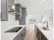Modern kitchen with an island, cooktop, white countertops, and stainless steel range hood at 15489 Hamlin Park Drive, Winter Garden, FL 34787
