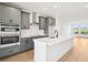 Stylish kitchen featuring stainless steel appliances, gray cabinets, and a center island at 15489 Hamlin Park Drive, Winter Garden, FL 34787