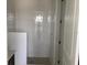 Modern bathroom showcasing a tiled shower area, new fixtures, and a door at 15489 Hamlin Park Drive, Winter Garden, FL 34787