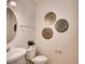 Cozy bathroom features a round mirror and decorative plates on the wall at 1550 Dalehurst Ln, Kissimmee, FL 34744