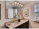 Dual sink bathroom features granite countertops, dark cabinetry, and a large mirror at 1550 Dalehurst Ln, Kissimmee, FL 34744