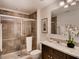 Well-lit bathroom with a glass-enclosed shower, granite countertop, and stylish dark cabinetry at 1550 Dalehurst Ln, Kissimmee, FL 34744