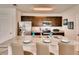 Open kitchen featuring granite countertops, stainless steel appliances, a breakfast bar with seating, and dark cabinetry at 1550 Dalehurst Ln, Kissimmee, FL 34744