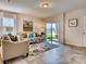 Inviting living room featuring tile floors, comfortable seating, stylish decor, and sliding glass doors to outdoor area at 1550 Dalehurst Ln, Kissimmee, FL 34744