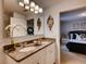 Well-lit bathroom featuring double vanity with granite countertops, and a glimpse into a bedroom at 1554 Dalehurst Ln, Kissimmee, FL 34744