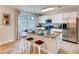 Bright kitchen featuring stainless steel appliances, granite counters, island with seating and tile flooring at 1554 Dalehurst Ln, Kissimmee, FL 34744