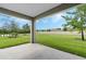 Covered patio with a view of a large, well-maintained backyard and surrounding trees at 1858 Waggoner St, Kissimmee, FL 34744